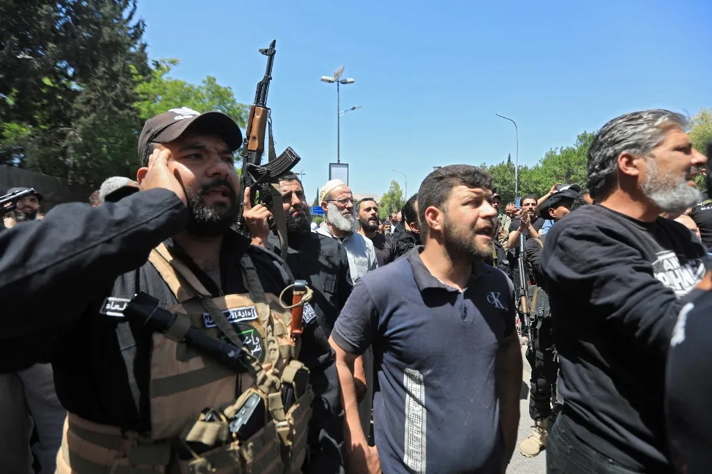 People chant slogans during the funeral of a man in the capital Damascus on April 29, 2025, who was killed during overnight sectarian clashes that left nine people including six Druze fighters dead. The clashes, sparked by the circulation on social media of an audio recording deemed blasphemous, were met with condemnation from leaders of the Druze religious minority. (Photo by Bakr ALKASEM / AFP)