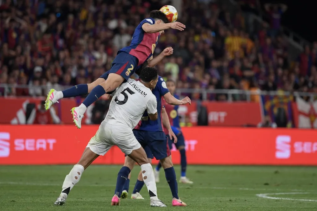 Barcelona's Spanish defender #02 Pau Cubarsi wins a header over Real Madrid's English midfielder #05 Jude Bellingham during their Spanish Cup, Copa del Rey (King's Cup) final football match between FC Barcelona and Real Madrid CF at La Cartuja stadium in Seville on April 26, 2025. (Photo by Josep LAGO / AFP)