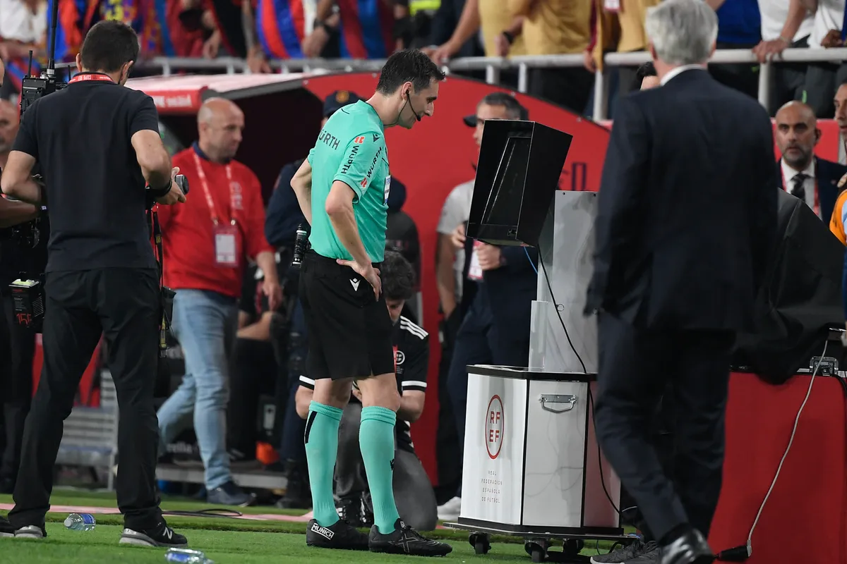 Spanish referee Ricardo De Burgos Bengoetxea checks the VAR during their Spanish Cup, Copa del Rey (King's Cup) final football match between FC Barcelona and Real Madrid CF at La Cartuja stadium in Seville on April 26, 2025. (Photo by Josep LAGO / AFP)