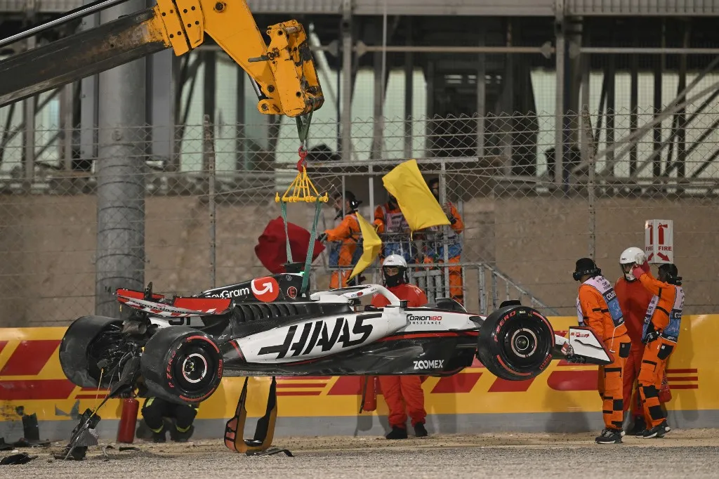 A crane lifts the car of Haas F1 Team's French driver Esteban Ocon during the qualifying session ahead of the Bahrain Formula One Grand Prix at the Bahrain International Circuit in Sakhir on April 12, 2025. (Photo by Andrej ISAKOVIC / AFP)
