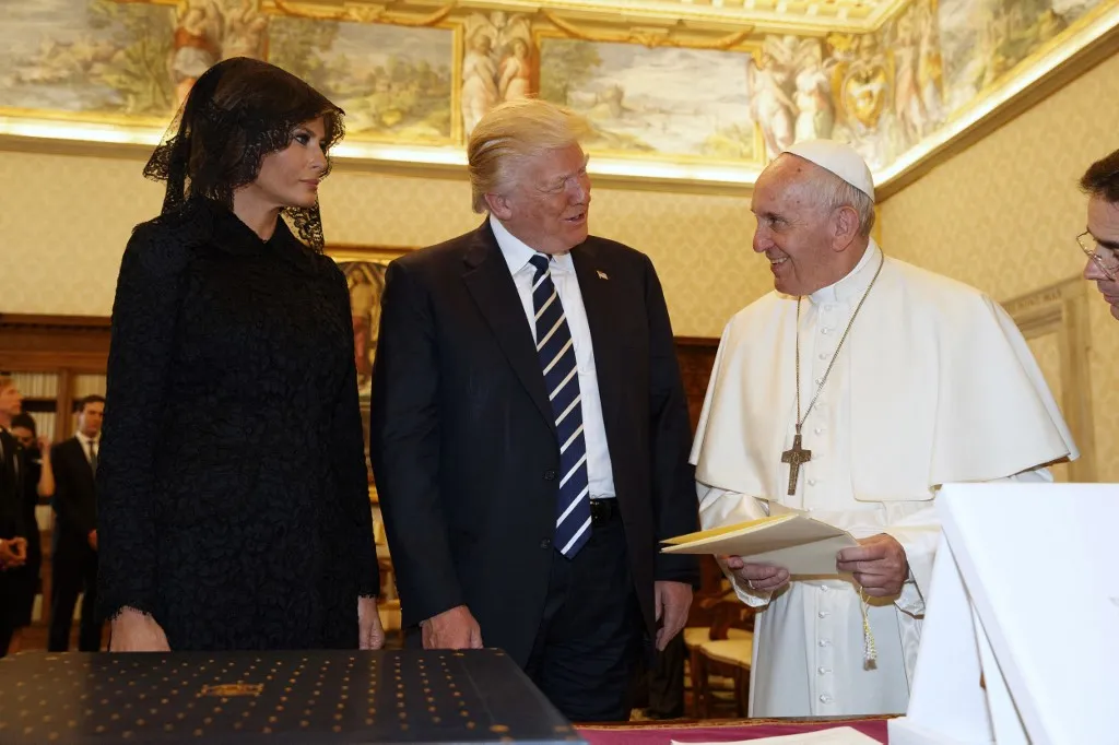 Pope Francis (R) exchanges gifts with US President Donald Trump and US First Lady Melania Trump during a private audience at the Vatican on May 24, 2017. US President Donald Trump met Pope Francis at the Vatican today in a keenly-anticipated first face-to-face encounter between two world leaders who have clashed repeatedly on several issues. (Photo by Evan Vucci / POOL / AFP)