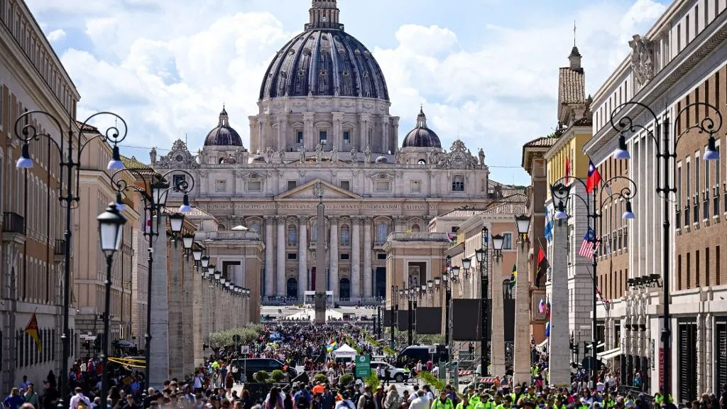 Visitors walk on Via della Conciliazione street with a view of The Vatican's St Peter's Basilica, in Rome on April 24, 2025. The Vatican said on April 24, 2025, that nearly 50,000 people had so far paid their respects to Pope Francis, whose body is lying in state at St Peter's Basilica for three days before his funeral. (Photo by Piero CRUCIATTI / AFP)