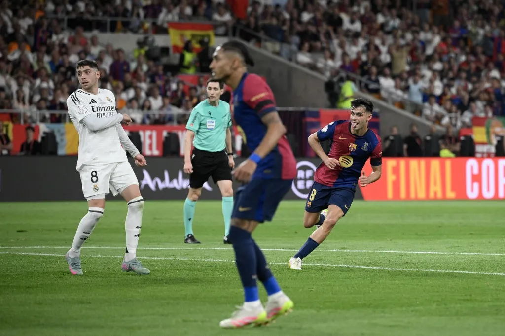 Barcelona's Spanish midfielder #08 Pedri (R) celebrates scoring the opening goal during their Spanish Cup, Copa del Rey (King's Cup) final football match between FC Barcelona and Real Madrid CF at La Cartuja stadium in Seville on April 26, 2025. (Photo by Josep LAGO / AFP)