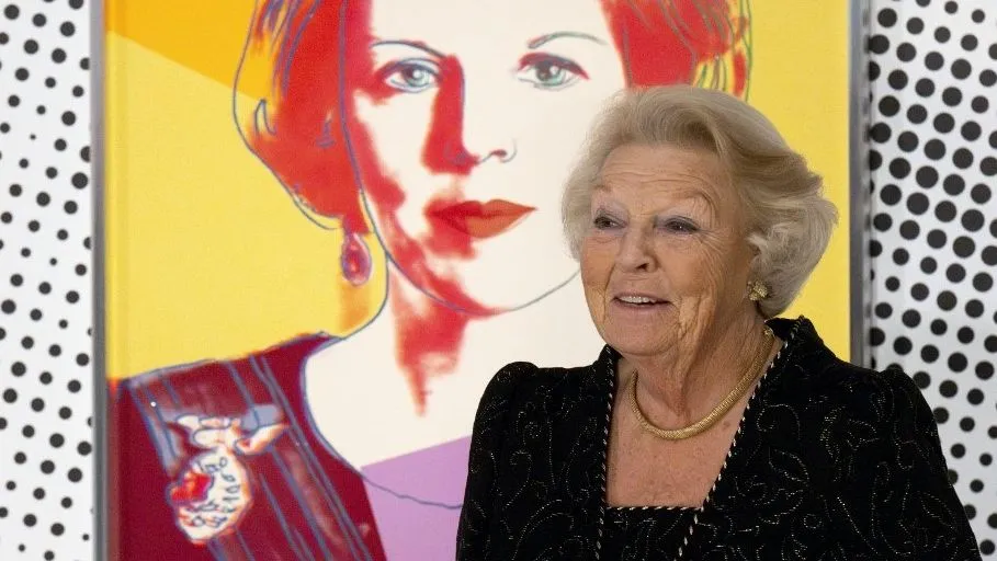 Princess Beatrix of the Netherlands poses in front of her portrait made by US artist Andy Warhol as she attends the preview of 'Queens by Andy Warhol' at the Het Loo Palace in Apeldoorn on October 10, 2024. In 1985, US artist Andy Warhol made a series of sixteen silkscreen prints of the only reigning queens in the world at the time including four portraits of the then Queen Beatrix (she abdicated in favour of King Willem Alexander in 2013). (Photo by Nick Gammon / AFP) / RESTRICTED TO EDITORIAL USE - MANDATORY MENTION OF THE ARTIST UPON PUBLICATION - TO ILLUSTRATE THE EVENT AS SPECIFIED IN THE CAPTION