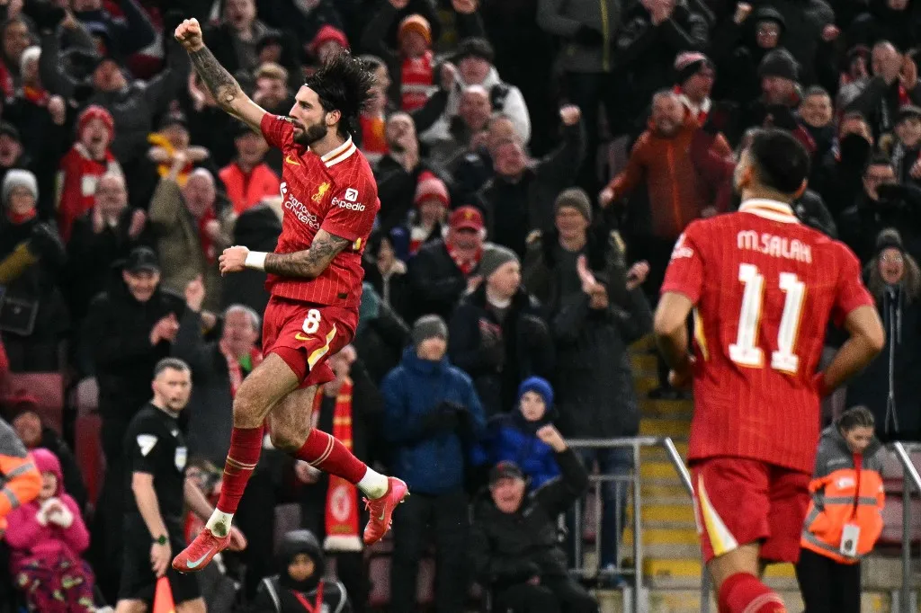 Liverpool's Hungarian midfielder #08 Dominik Szoboszlai celebrates scoring the team's third goal during the English League Cup semi-final second leg football match between Liverpool and Tottenham Hotspur at Anfield in Liverpool, north west England on February 6, 2025. (Photo by Oli SCARFF / AFP) / RESTRICTED TO EDITORIAL USE. No use with unauthorized audio, video, data, fixture lists, club/league logos or 'live' services. Online in-match use limited to 120 images. An additional 40 images may be used in extra time. No video emulation. Social media in-match use limited to 120 images. An additional 40 images may be used in extra time. No use in betting publications, games or single club/league/player publications. / 