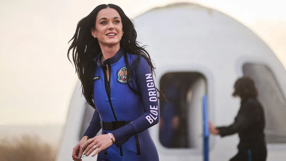 This handout photo from Blue Origin shows US singer Katy Perry upon return to Earth after a flight on Blue Origin New Shepard NS-31, which brought the passengers beyond the Karman line -- the internationally recognized boundary of space, in Van Horn, West Texas, April 14, 2025. Pop star Katy Perry completed a brief foray into space Monday, roaring to the edge of the cosmos with an all-women crew on one of billionaire Jeff Bezos's rockets. The "Firework" and "California Gurls" singer was lofted more than 60 miles (100 kilometers) above the Earth's surface in a vessel from Blue Origin, the space company owned by the Amazon founder. Five other women -- including Bezos's fiancee Lauren Sanchez -- were on the flight, which took off from western Texas shortly after 8:30 am (1330 GMT) before safely landing again some (Photo by Handout / BLUE ORIGIN / AFP) / RESTRICTED TO EDITORIAL USE - MANDATORY CREDIT "AFP PHOTO / HANDOUT / BLUE ORIGIN " - NO MARKETING NO ADVERTISING CAMPAIGNS - DISTRIBUTED AS A SERVICE TO CLIENTS