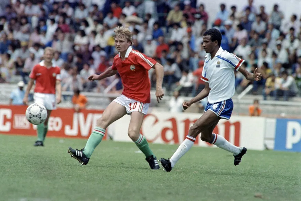 French player Jean Tigana (R) kicks for the ball against his Hungarian opponent Lajos Detari during the World Cup first round soccer match between France and Hungary, 09 June 1986 in Leon. (Photo by STAFF / AFP)