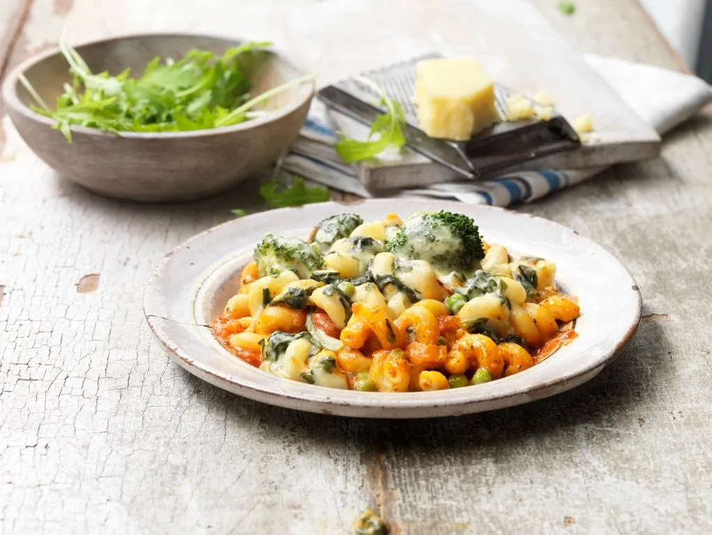 Food, vegetarian meals, vegetable pasta bake, melted cheese, onions, peas, broccoli, rocket in bowl, cheese and cheese grater, vintage bowl, rustic wooden table (Photo by Diana Miller / Connect Images / Connect Images via AFP)