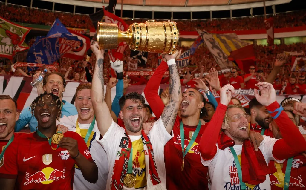 Leipzig's Hungarian midfielder Dominik Szoboszlai (C) celebrates with the trophy after their team won the German Cup (DFB Pokal) final football match RB Leipzig v Eintracht Frankfurt in Berlin, Germany, on June 3, 2023. (Photo by Odd ANDERSEN / AFP) / DFB REGULATIONS PROHIBIT ANY USE OF PHOTOGRAPHS AS IMAGE SEQUENCES AND QUASI-VIDEO.
