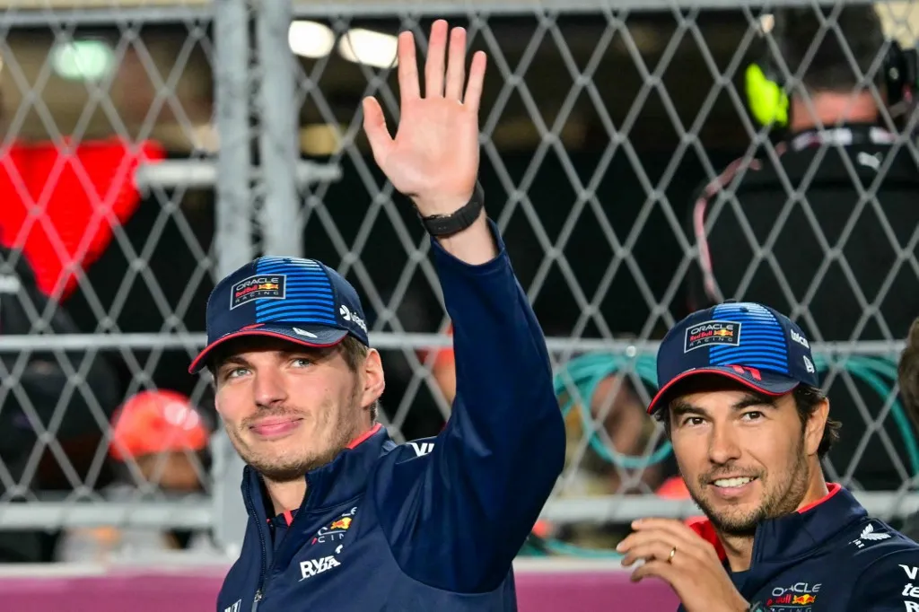 Red Bull Racing's Dutch driver Max Verstappen (L) and his teammate Red Bull Racing's Mexican driver Sergio Perez arrive to participate in the drivers' parade ahead of the Qatari Formula One Grand Prix at the Lusail International Circuit in Lusail, north of Doha, on December 1, 2024. (Photo by Giuseppe CACACE / AFP)