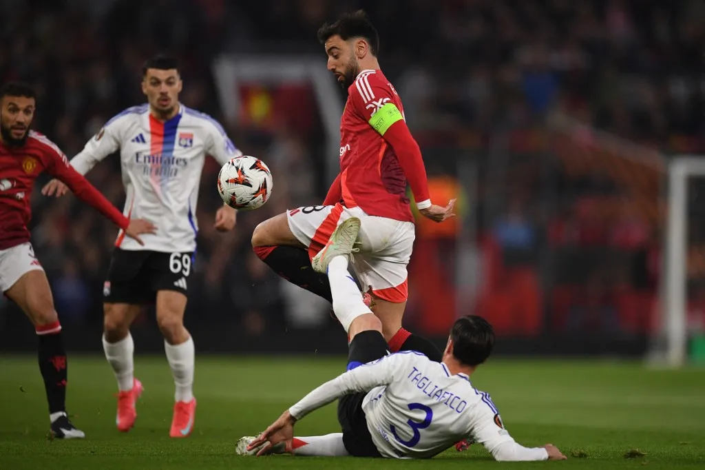 Lyon's Argentinian defender #03 Nicolas Tagliafico (R) vies with Manchester United's Portuguese midfielder #08 Bruno Fernandes (C) during the UEFA Europa league quarter-final final, second leg football match between Manchester United and Lyon at Old Trafford stadium in Manchester, north west England, on April 17, 2025. (Photo by Oli SCARFF / AFP)