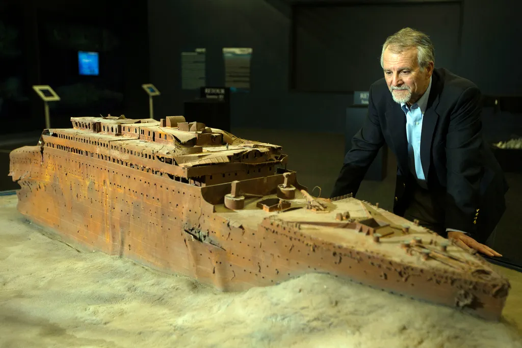Paul-Henri Nargeolet, director of a deep ocean research project dedicated to the Titanic, poses next to a miniature version of the sunken ship inside a new exhibition, at 'Paris Expo', on May 31, 2013, in Paris. Over a century after the sinking of the fam