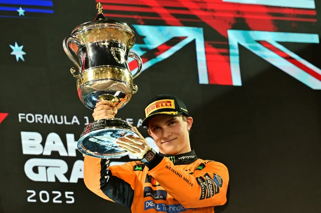 McLaren's Australian driver Oscar Piastri lifts the throphy on podium after winning the Bahrain Formula One Grand Prix at the Bahrain International Circuit in Sakhir on April 13, 2025. (Photo by Giuseppe CACACE / AFP)