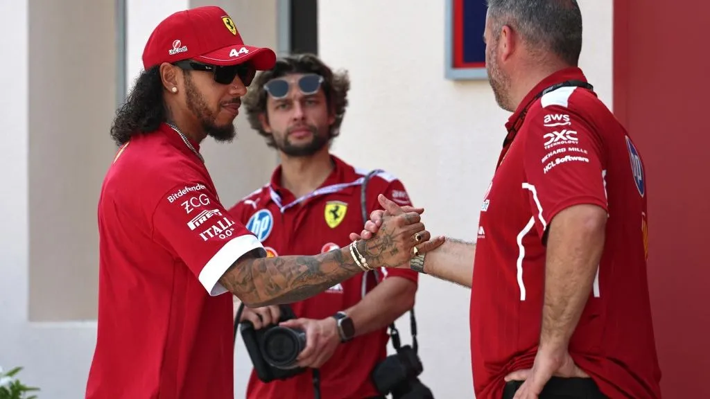 Ferrari's British driver Lewis Hamilton greets a mechanic as he arrives at the Bahrain International Circuit in Sakhir on April 10, 2025, ahead of the Bahrain Formula One Grand Prix weekend. (Photo by Fadel SENNA / AFP)