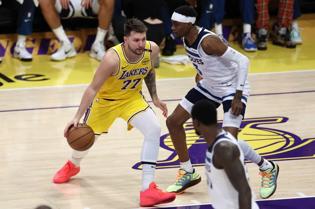 LOS ANGELES, CALIFORNIA - APRIL 22: Luka Doncic #77 of the Los Angeles Lakers dribbles the ball while being guarded by Jaden McDaniels #3 of the Minnesota Timberwolves in the first quarter in Game Two of the Western Conference First Round NBA Playoffs at Crypto.com Arena on April 22, 2025 in Los Angeles, California. NOTE TO USER: User expressly acknowledges and agrees that, by downloading and or using this photograph, User is consenting to the terms and conditions of the Getty Images License Agreement.   Sean M. Haffey/Getty Images/AFP (Photo by Sean M. Haffey / GETTY IMAGES NORTH AMERICA / Getty Images via AFP)