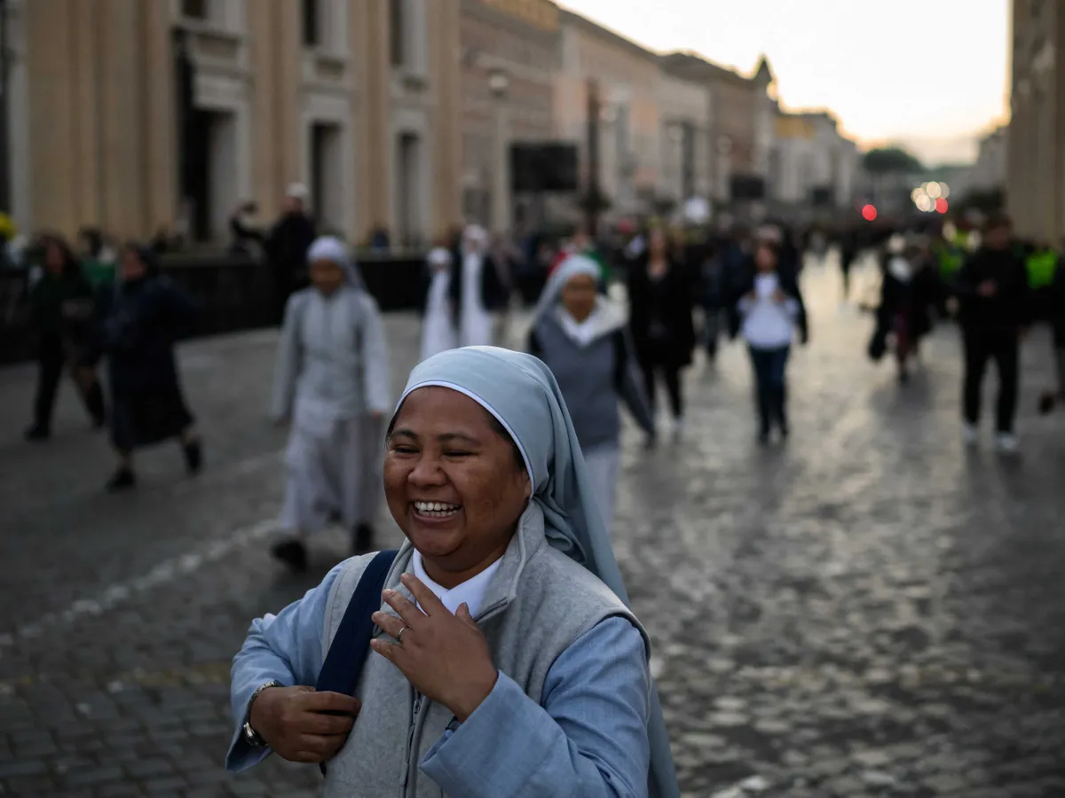 Ferenc pápa, temetés, Ferencpápa, Ferencpápatemetése, Ferenc pápa halála, Ferencpápahalála,  római katolikus egyházfő temetése, Róma, 2025.04.26.,  A nun reacts as she arrives near the Vatican ahead of late Pope Francis' funeral, in Rome on April 26, 2025. Pope Francis, champion of the poor and the Church's first Latin American leader, will be honoured April 26 with a funeral attended by world leaders and tens of thousands of Catholic faithful. The Argentine pontiff, who died on April 21, 2025, aged 88, sought to create a more open-minded Church during his 12-year papacy, and many emotional tributes have been made -- with 250,000 people paying respects at his coffin in St Peter's Basilica. (Photo by JEFF PACHOUD / AFP)