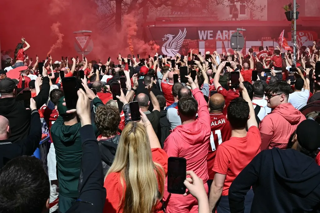 Fans crowd around as the team coach arrives ahead of the English Premier League football match between Liverpool and Tottenham Hotspur at Anfield in Liverpool, north west England on April 27, 2025. (Photo by Paul ELLIS / AFP) Szoboszlai