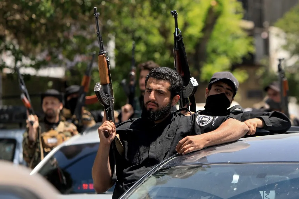 Members of Syria's security forces stand guard next to their vehicles in the capital Damascus on April 29, 2025, following overnight sectarian clashes that left nine people including six Druze fighters dead. The clashes, sparked by the circulation on social media of an audio recording deemed blasphemous, were met with condemnation from leaders of the Druze religious minority. (Photo by Bakr ALKASEM / AFP)