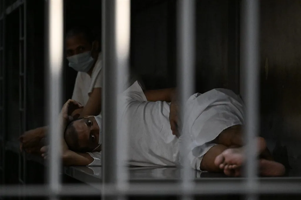 Inmates remain in their cell as Costa Rica's Minister of Security Gerald Campos tours the Centre for Terrorism Confinement (CECOT) during a visit organized by El Salvador's Presidency in Tecoluca, El Salvador, on April 4, 2025. (Photo by Marvin RECINOS / AFP)