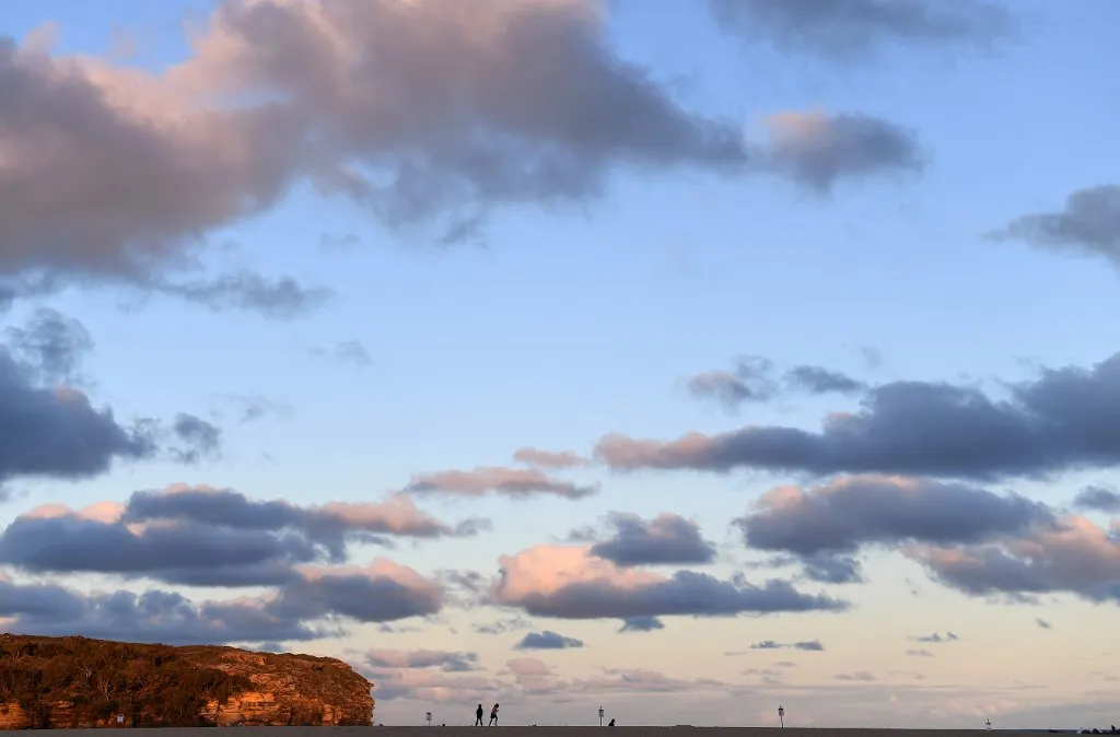 This picture taken on September 25, 2018 shows children playing at sunset on Wattamolla Beach, south of Sydney. (Photo by Saeed KHAN / AFP)