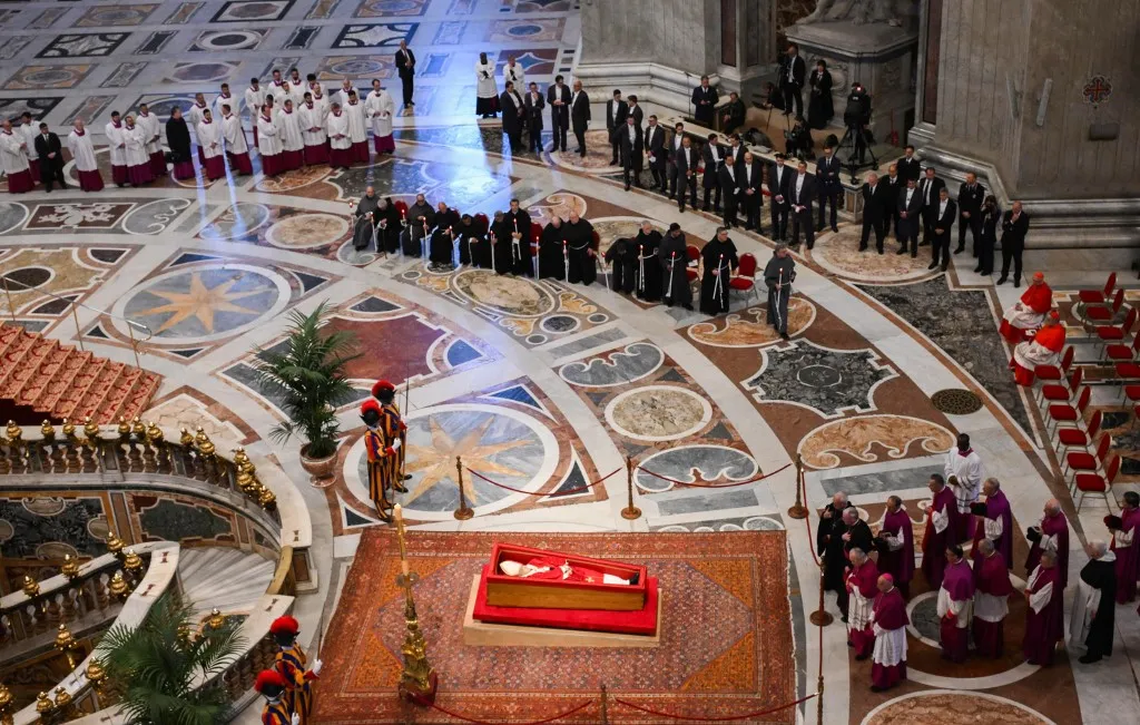 This photograph shows Pope Francis' coffin (bottom) with members of the clergy attending a ceremony inside St Peter's Basilica following the procession of the late Pope's coffin from the chapel of Santa Marta to St Peter's Basilica, in the Vatican on April 23, 2025. The Pope died of a stroke, the Vatican announced hours after the death on April 21, 2025, of the 88-year-old reformer who inspired devotion but riled traditionalists during 12 years leading the Catholic Church. (Photo by Alessandro DI MEO / POOL / AFP)