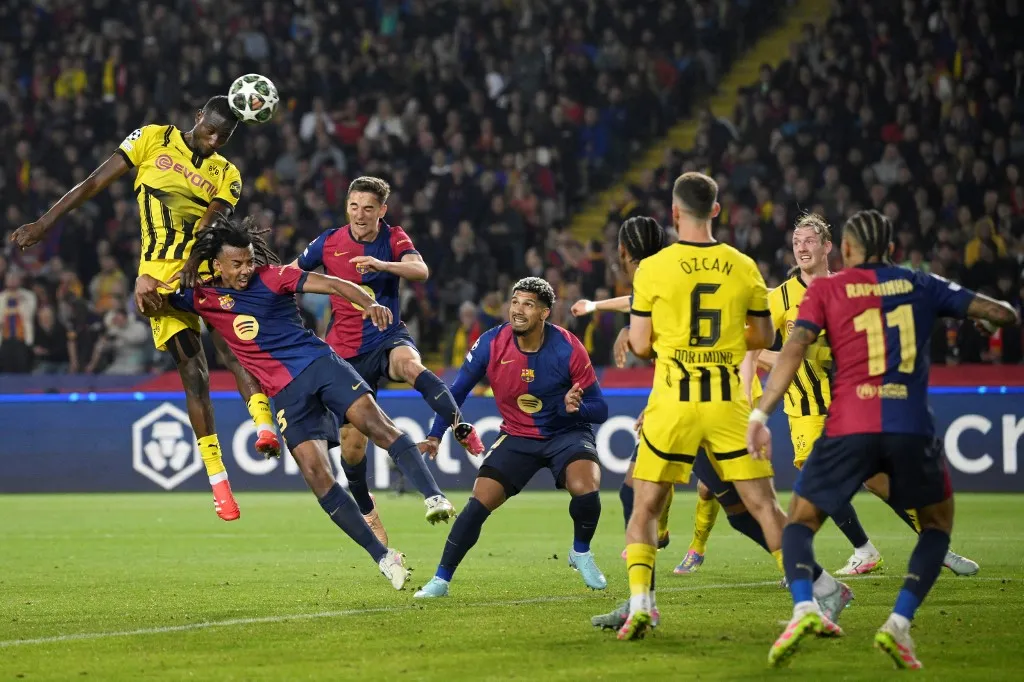 Borussia Dortmund's Guinean forward #09 Sehrou Guirassy jumps for the ball next to Barcelona's French defender #23 Jules Kounde and Barcelona's Spanish midfielder #06 Pablo Gavi during the UEFA Champions League Quarter final First Leg football match between FC Barcelona and BVB Borussia Dortmund  at the Estadi Olimpic Lluis Companys in Barcelona on April 9, 2025. (Photo by Josep LAGO / AFP)