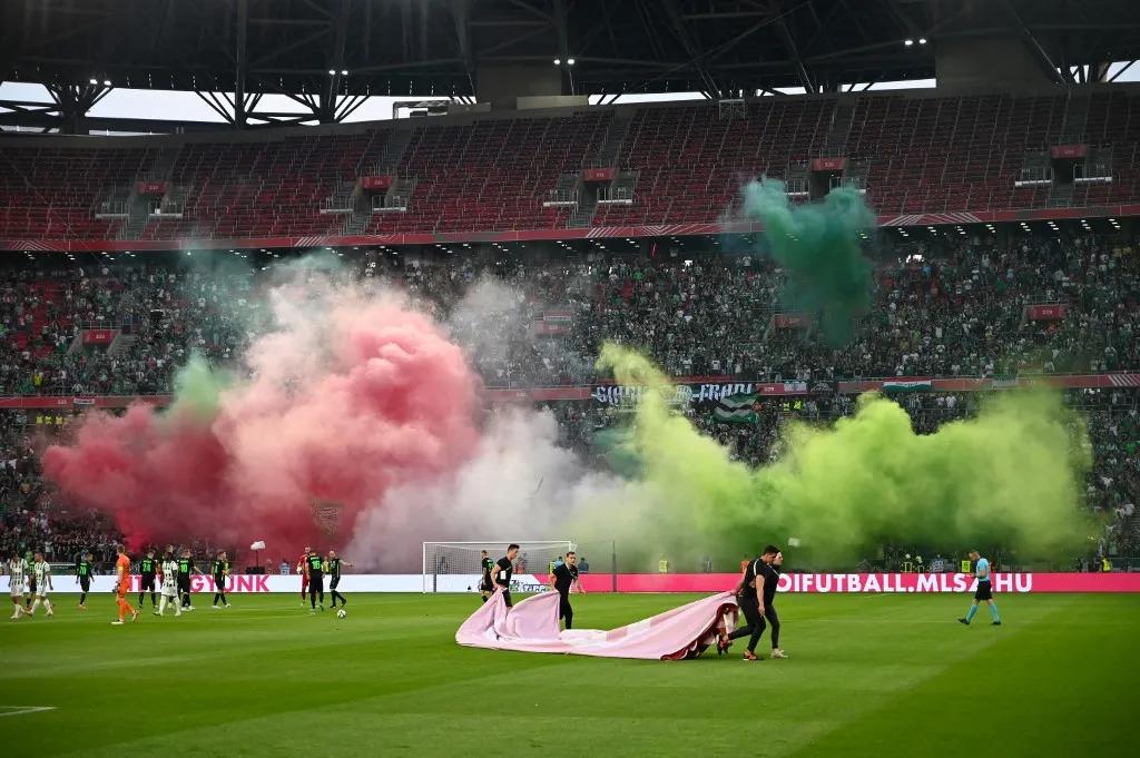 Hungarian fans of TC Ferencvaros light smoke candles in the Hungarian colours red-white-green in Puskas Arena on May 11, 2022, prior to the final of the Hungarian football cup between TC Ferencvaros and FC Paks. Ferencvaros won by 3-0 and the trophy. (Photo by ATTILA KISBENEDEK / AFP)