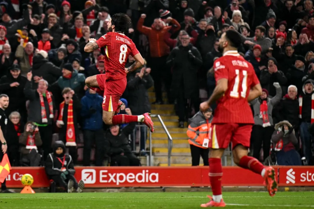 Liverpool's Hungarian midfielder #08 Dominik Szoboszlai celebrates scoring the team's third goal during the English League Cup semi-final second leg football match between Liverpool and Tottenham Hotspur at Anfield in Liverpool, north west England on February 6, 2025. (Photo by Oli SCARFF / AFP) / RESTRICTED TO EDITORIAL USE. No use with unauthorized audio, video, data, fixture lists, club/league logos or 'live' services. Online in-match use limited to 120 images. An additional 40 images may be used in extra time. No video emulation. Social media in-match use limited to 120 images. An additional 40 images may be used in extra time. No use in betting publications, games or single club/league/player publications. / 