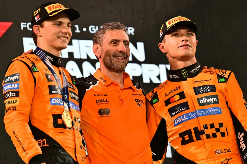 McLaren's Australian driver Oscar Piastri and McLaren's British driver Lando Norris stand on the podium with McLaren team principal Andrea Stella after the Bahrain Formula One Grand Prix at the Bahrain International Circuit in Sakhir on April 13, 2025. (Photo by Giuseppe CACACE / AFP)