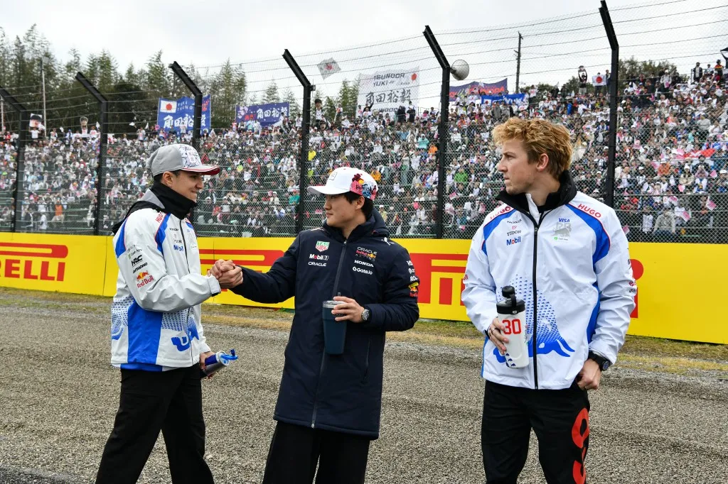 Racing Bulls driver Isack Hadjar, Red Bull Racing driver Yuki Tsunoda, and Racing Bulls driver Liam Lawson talk on the track during the driver's parade prior to the F1 Grand Prix of Japan in Suzuka, Japan, on April 6. (Photo by Yusuke Harada/NurPhoto) (Photo by Yusuke Harada / NurPhoto / NurPhoto via AFP)