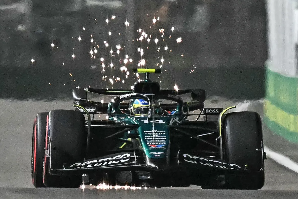 Sparks fly as Aston Martin's Spanish driver Fernando Alonso drives during the qualifying session ahead of the Formula One Singapore Grand Prix night race at the Marina Bay Street Circuit in Singapore on September 21, 2024. (Photo by Lillian SUWANRUMPHA / AFP)