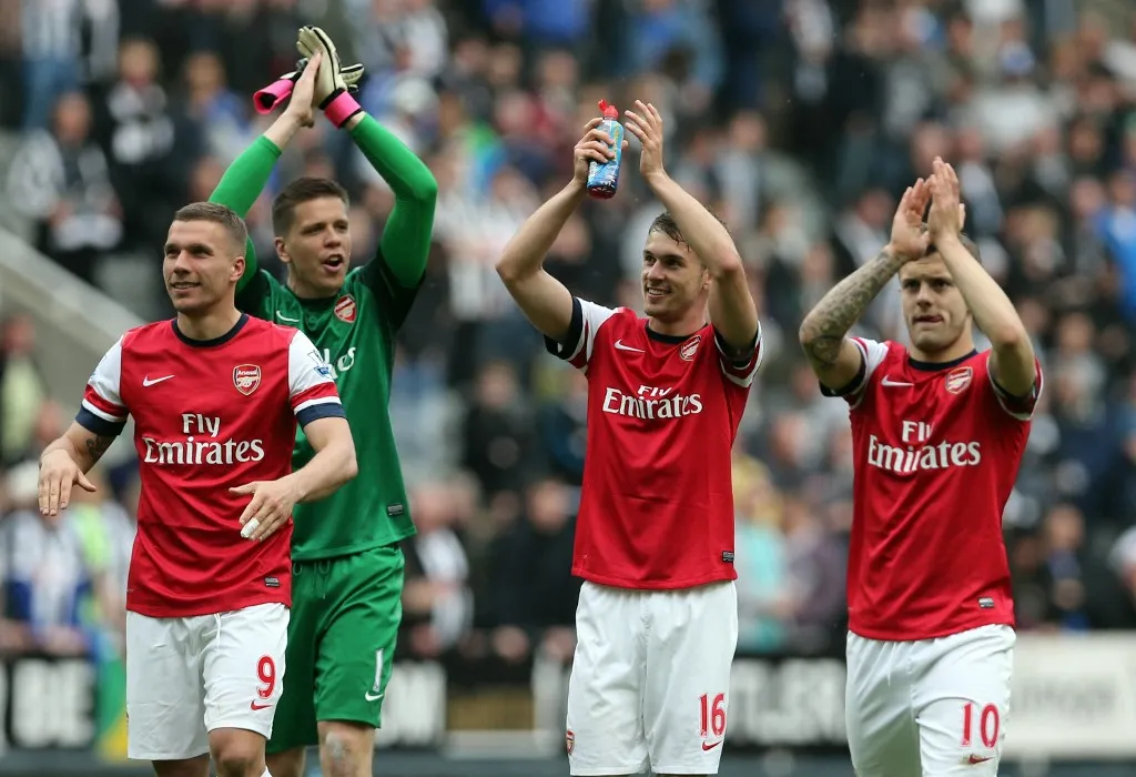 (L-R) Arsenal's Polish-born German striker Lukas Podolski, Polish goalkeeper Wojciech Szczesny, Welsh midfielder Aaron Ramsey and English midfielder Jack Wilshere acknowledge the crowd as they celebrate their victory after the final whistle in the English Premier League football match between Newcastle United and Arsenal at St James' Park in Newcastle Upon Tyne, northeast England, on May 19, 2013. Arsenal won the race for fourth place in the Premier League with a 1-0 victory at Newcastle.  AFP PHOTO / IAN MACNICOL

RESTRICTED TO EDITORIAL USE. No use with unauthorized audio, video, data, fixture lists, club/league logos or live services. Online in-match use limited to 45 images, no video emulation. No use in betting, games or single club/league/player publications. (Photo by Ian MacNicol / AFP)