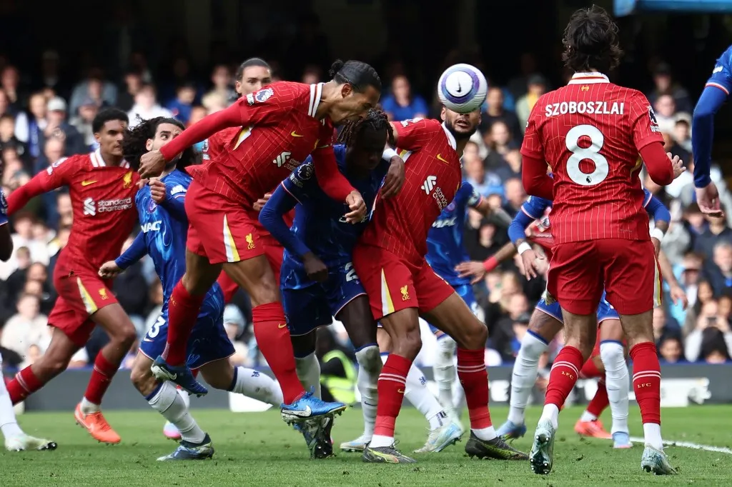 Liverpool's Dutch defender #04 Virgil van Dijk (C) heads in their first goal during the English Premier League football match between Chelsea and Liverpool at Stamford Bridge in London on May 4, 2025. (Photo by HENRY NICHOLLS / AFP) / RESTRICTED TO EDITORIAL USE. No use with unauthorized audio, video, data, fixture lists, club/league logos or 'live' services. Online in-match use limited to 120 images. An additional 40 images may be used in extra time. No video emulation. Social media in-match use limited to 120 images. An additional 40 images may be used in extra time. No use in betting publications, games or single club/league/player publications. /