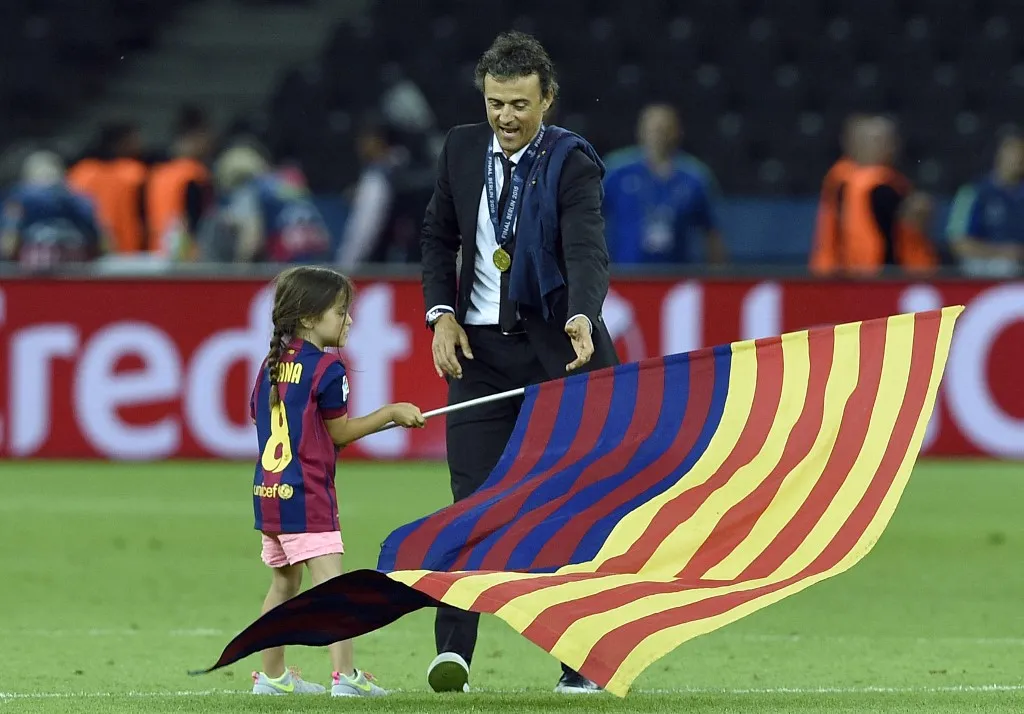 Barcelona's coach Luis Enrique and his daughter Xana wave a flag after the UEFA Champions League Final football match between Juventus and FC Barcelona at the Olympic Stadium in Berlin on June 6, 2015. FC Barcelona won the match 1-3.        AFP PHOTO / LLUIS GENE (Photo by LLUIS GENE / AFP)