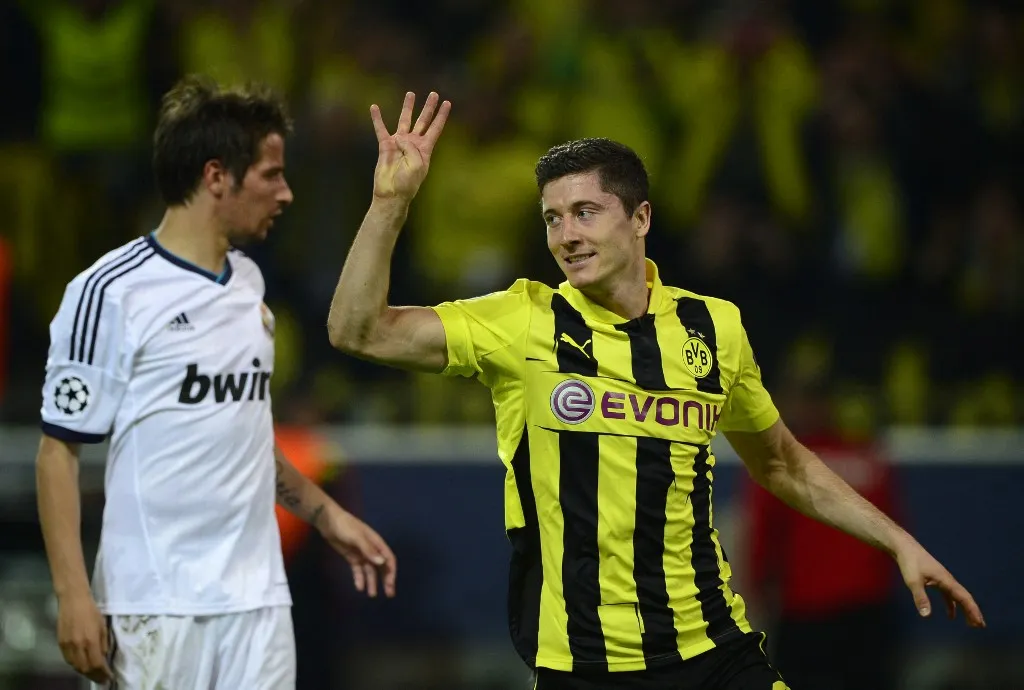 Dortmund's Polish striker Robert Lewandowski (R) celebrates after scoring a penalty to mark the 4-1 as Real Madrid's Portuguese defender Fabio Coentrao looks on during the UEFA Champions League semi final first leg football match between Borussia Dortmund and Real Madrid on April 24, 2013 in Dortmund, western Germany.      AFP PHOTO / JOHN MACDOUGALL (Photo by JOHN MACDOUGALL / AFP)