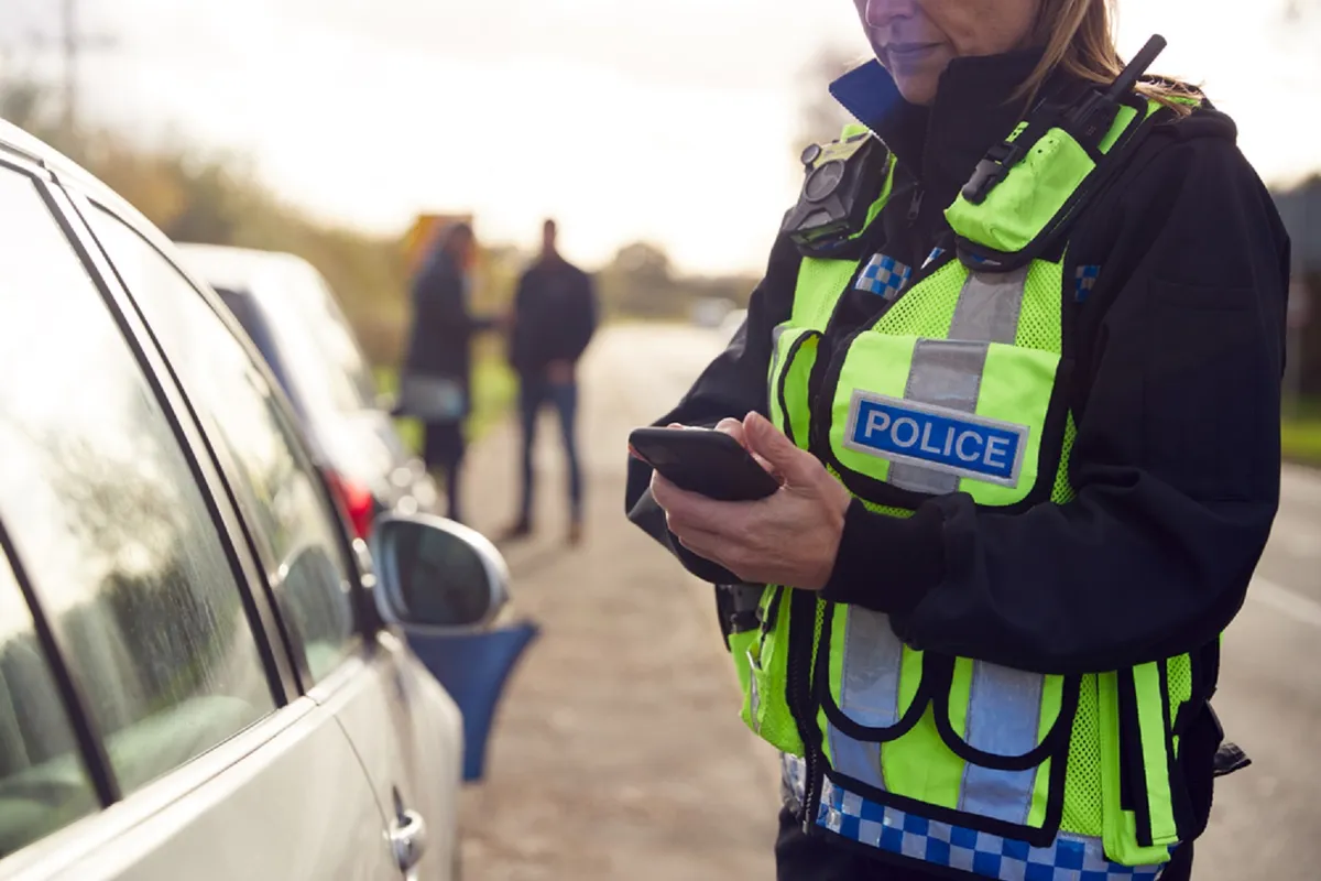 Female Traffic Police Officer Recording Details Of Road Traffic Accident On Mobile Phone, büntetés