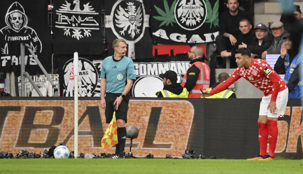 botrány, 04 May 2025, Rhineland-Palatinate, Mainz: Soccer: Bundesliga, FSV Mainz 05 - Eintracht Frankfurt, Matchday 32, Mewa Arena. Nadiem Amiri from Mainz is pelted with objects by Frankfurt fans. Photo: Torsten Silz/dpa - IMPORTANT NOTE: In accordance with the regulations of the DFL German Football League and the DFB German Football Association, it is prohibited to utilize or have utilized photographs taken in the stadium and/or of the match in the form of sequential images and/or video-like photo series. (Photo by TORSTEN SILZ / DPA / dpa Picture-Alliance via AFP)