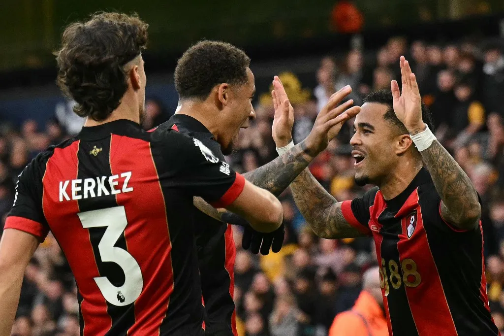 Bournemouth's Dutch striker #19 Justin Kluivert (R) celebrates scoring the team's third goal with Bournemouth's English midfielder #16 Marcus Tavernier (C) and Bournemouth's Hungarian defender #03 Milos Kerkez during the English Premier League football match between Wolverhampton Wanderers and Bournemouth at the Molineux stadium in Wolverhampton, central England on November 30, 2024. (Photo by Oli SCARFF / AFP) / RESTRICTED TO EDITORIAL USE. No use with unauthorized audio, video, data, fixture lists, club/league logos or 'live' services. Online in-match use limited to 120 images. An additional 40 images may be used in extra time. No video emulation. Social media in-match use limited to 120 images. An additional 40 images may be used in extra time. No use in betting publications, games or single club/league/player publications. / The erroneous mention[s] appearing in the metadata of this photo by Oli SCARFF has been modified in AFP systems in the following manner: [Bournemouth's English midfielder #16 Marcus Tavernier] instead of [Bournemouth's Scottish midfielder #10 Ryan Christie]. Please immediately remove the erroneous mention[s] from all your online services and delete it (them) from your servers. If you have been authorized by AFP to distribute it (them) to third parties, please ensure that the same actions are carried out by them. Failure to promptly comply with these instructions will entail liability on your part for any continued or post notification usage. Therefore we thank you very much for all your attention and prompt action. We are sorry for the inconvenience this notification may cause and remain at your disposal for any further information you may require.