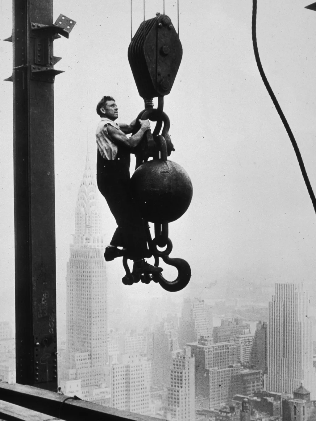 Az első felhőkarcolók építése,  A construction worker stands on crane pulley counterweight during the construction of the Empire State Building, New York, New York. mid to late 1930. The Chrysler building is behind him.  (Photo by Hulton Archive/Getty Ima