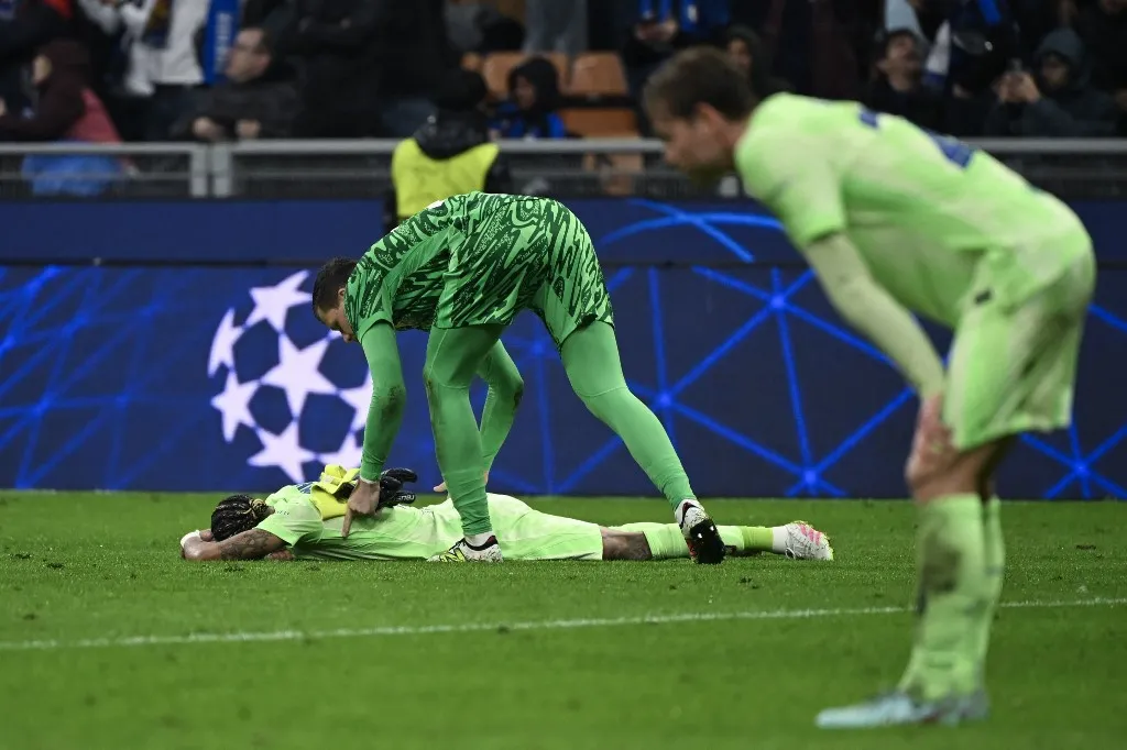 Barcelona's Polish goalkeeper #25 Wojciech Szczesny comforts Barcelona's Brazilian forward #11 Raphinha (L) after Inter Milan won the UEFA Champions League semi-final second leg football match between Inter Milan and FC Barcelona at the San Siro stadium in Milan on May 6, 2025. (Photo by PIERO CRUCIATTI / AFP)