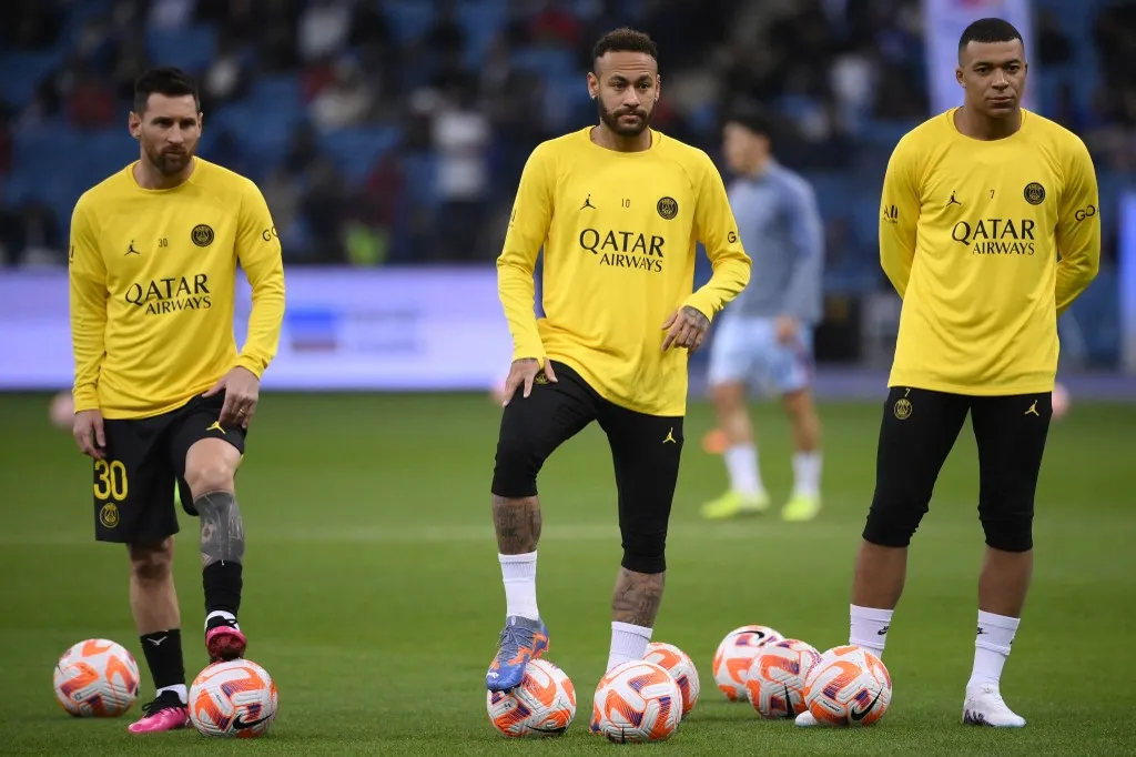 Paris Saint-Germain's Argentine forward Lionel Messi (L) Paris Saint-Germain's Brazilian forward Neymar (C) Paris Saint-Germain's French forward Kylian Mbappe (R) warm up ahead of the Riyadh Season Cup between the Riyadh All-Stars and Paris Saint-Germain at the King Fahd Stadium in Riyadh on January 19, 2023. (Photo by FRANCK FIFE / AFP)