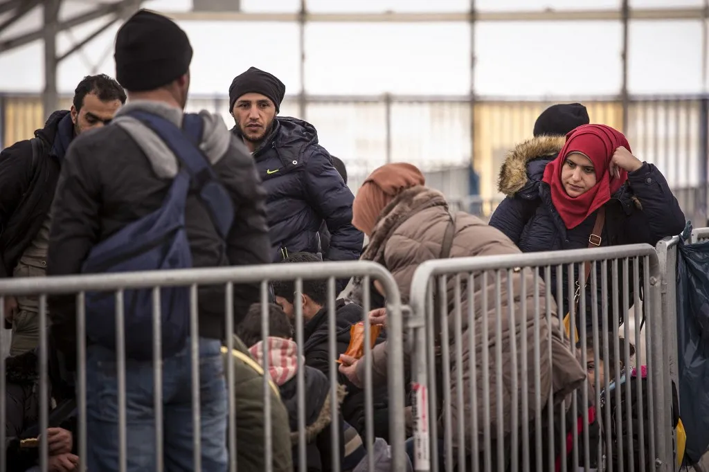 SPIELFELD, AUSTRIA-- Asylum-seekers from Syria and Iraq wait to be bused from the Austrian registration center on February 20, 2016, after crossing the border from Slovenia. Austria implemented new procedures limiting the number of asylum-seekers allowed each day, creating a domino-effect down the Balkan route and creating backups in Greece and Serbia. (Photo by Jodi Hilton/NurPhoto) (Photo by JODI HILTON / NurPhoto / NurPhoto via AFP)