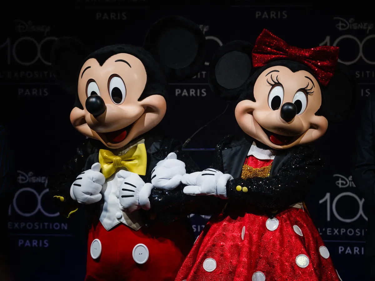 Forma-1 Employees, dressed as Mickey Mouse and Minnie Mouse perform during a press preview on the eve of the opening of the exhibition "Disney 100 - The Exhibition" at Paris Expo, Porte de Versailles congress centre in Paris on April 9, 2025. The Walt Disney Archives open their doors to unveil over 250 objects and works of art, costumes, props, and iconic memorabilia. (Photo by Dimitar DILKOFF / AFP)