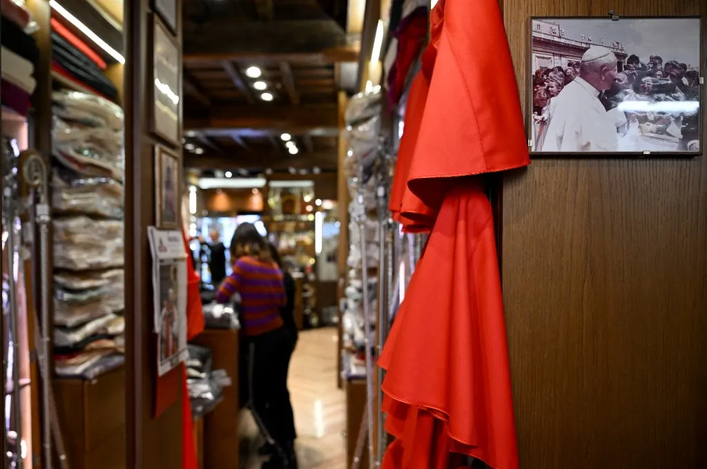 A picture of Pope John Paul II is hanged on a wall of the shop of Italian ecclesiastical tailor, Raniero Mancinelli, 86, in Borgo Pio, a neighborhood close to the Vatican, on November 19, 2024 in Rome. Days have turned into a race against time for Raniero Mancinelli as a third of the 21 prelates who will be made cardinals by Pope Francis on December 7, 2024 have placed orders with him. (Photo by Tiziana FABI / AFP)