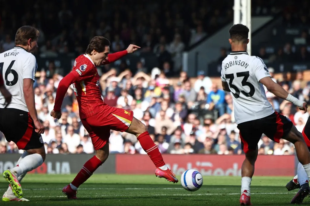 Liverpool's Italian striker #14 Federico Chiesa shoots but fails to score during the English Premier League football match between Fulham and Liverpool at Craven Cottage in London on April 6, 2025. (Photo by HENRY NICHOLLS / AFP) / RESTRICTED TO EDITORIAL USE. No use with unauthorized audio, video, data, fixture lists, club/league logos or 'live' services. Online in-match use limited to 120 images. An additional 40 images may be used in extra time. No video emulation. Social media in-match use limited to 120 images. An additional 40 images may be used in extra time. No use in betting publications, games or single club/league/player publications. / 