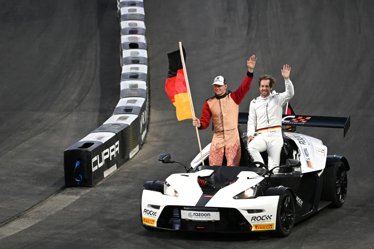 Former Formula One driver and world champion Sebastian Vettel (R) and teammate Mick Schumacher wave to spectators ahead of the Race of Champions at Accor Stadium in Sydney on March 7, 2025. (Photo by Saeed KHAN / AFP) / -- IMAGE RESTRICTED TO EDITORIAL USE - STRICTLY NO COMMERCIAL USE --