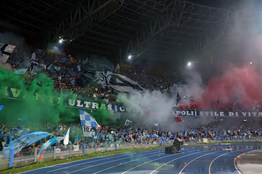 Napoli supporters light green, white, and red flares (colours of Italy's national flag) during the Italian Serie A football match between Napoli and Cagliari at the Diego Armando Maradona stadium in Naples on May 23, 2025. (Photo by Carlo Hermann / AFP)