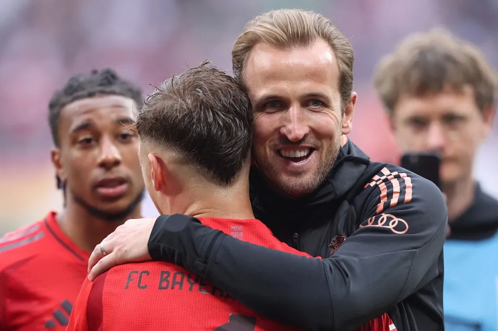 (FILES) Bayern Munich's English forward #09 Harry Kane hugs Bayern Munich's German midfielder #06 Joshua Kimmich after the German first division Bundesliga football match between RB Leipzig and FC Bayern Munich in Leipzig, eastern Germany on May 3, 2025. Bayern Munich won the league on May 4, 2025 for the 34th time after Leverkusen failed to win away to Freiburg with English forward Harry Kane winning his first title. (Photo by RONNY HARTMANN / AFP)