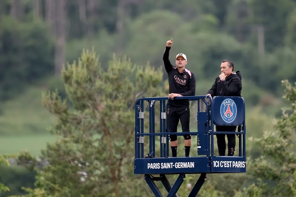 Paris Saint-Germain's Spanish headcoach Luis Enrique (L) leads a training session from a crane platform next to club's psychologist Joaquin Valdes Fonseca (R) ahead of the UEFA Champions League final football match at the club training camp in Poissy, west of Paris, on May 21, 2025. PSG will play the French Cup final football match against Stade de Reims on May 24, 2025 and Champions League's against Inter Milan on May 31, 2025. (Photo by FRANCK FIFE / AFP)