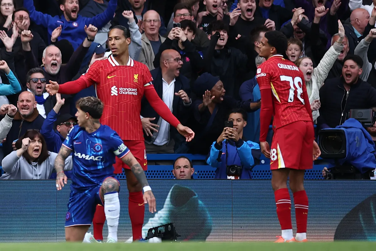 Liverpool's English defender #78 Jarell Quansah (R) reacts after a clearance from Liverpool's Dutch defender #04 Virgil van Dijk (L) deflects off him back into the Liverpool goal for an own goal during the English Premier League football match between Chelsea and Liverpool at Stamford Bridge in London on May 4, 2025. (Photo by HENRY NICHOLLS / AFP) / RESTRICTED TO EDITORIAL USE. No use with unauthorized audio, video, data, fixture lists, club/league logos or 'live' services. Online in-match use limited to 120 images. An additional 40 images may be used in extra time. No video emulation. Social media in-match use limited to 120 images. An additional 40 images may be used in extra time. No use in betting publications, games or single club/league/player publications. /